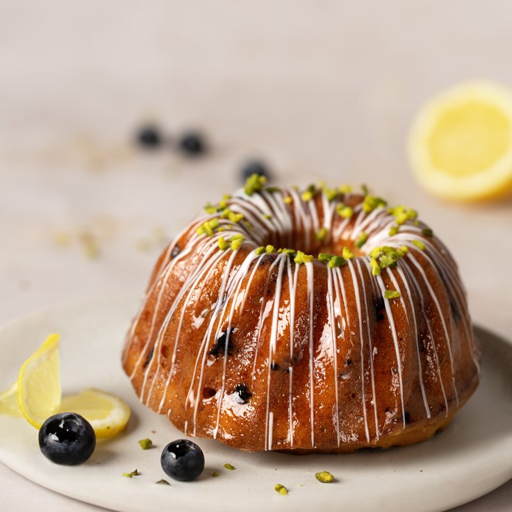 Bundt cake with icing and chopped pistachios.